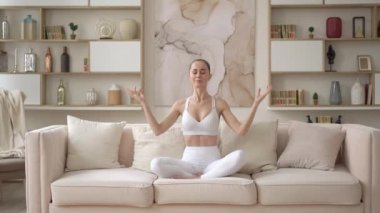 Memlekette meditasyon yapan çok kültürlü, düşünceli genç bir bayan. Nilüfer çiçekli koltukta oturmuş yoga, sağlık, rahatlama ve zihinsel terapi kavramı için yoga yapan sakin, bin yıllık çekici bir kız.