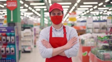 Genç satıcı süpermarkette el ele tutuşurken kırmızı maske takıyor. Coronavirus mermer covid 19 koruma. Corona virüsünün konsept yaymasını durdur.
