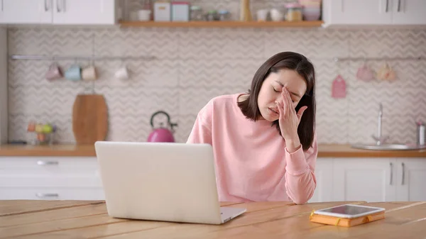 Gestresste, überarbeitete Geschäftsfrau, die von zu Hause aus arbeitet, erschöpft vom Laptop. Müde asiatische Dame leidet unter Kopfschmerzen, Fernarbeits-Konzept — Stockfoto