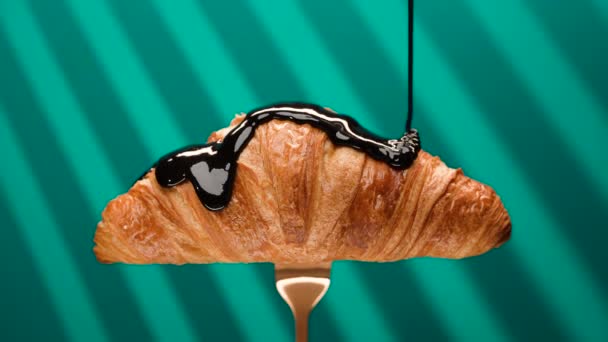 Primo piano salsa al cioccolato versare su un croissant fresco, prodotto dolce e naturale, gustoso dolce francese croccante cotto a colazione, pasticceria fatta a mano, antipasto prodotto da forno al rallentatore — Video Stock