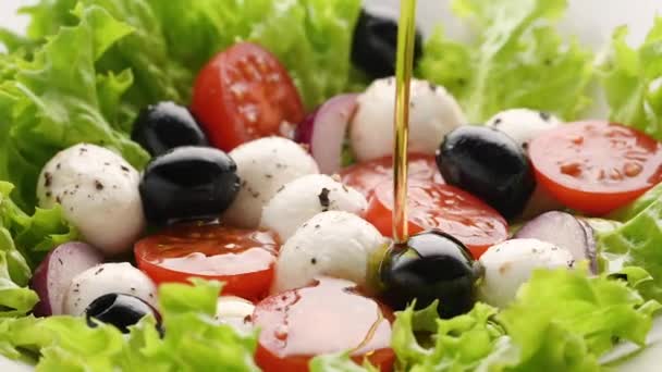 Häll olivolja över färsk hemlagad vegetarisk sallad. Matlagning hälsosam grönsakssallad med mozzarella ost och körsbärstomater, hälsosam lunch, ren ekologisk kost äta, kost vegan mat koncept — Stockvideo