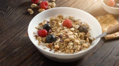 Ev yapımı müsli granola kahvaltısı, sade yoğurt, yabanmersini ve ahududu ve ahşap arka planda. Sağlıklı yiyecekler, vejetaryen diyeti, alerji dostu, kilo kaybı detoks konsepti.
