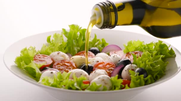 Vierta aceite de oliva sobre ensalada vegetariana casera fresca. Cocinar ensalada de verduras saludables con queso mozzarella y tomates cherry, almuerzo saludable, alimentación ecológica limpia, dieta concepto de comida vegana — Vídeo de stock