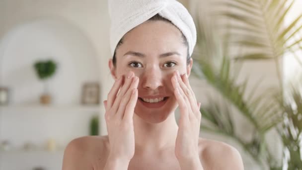 Menina multi étnica feliz olhando no espelho toque pele rosto macio saudável após o tratamento diário. Sorrindo millennial mestiço asiático feminino fazer massagem satisfeito com procedimentos faciais. Conceito de cuidados com a pele. — Vídeo de Stock