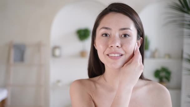 Приваблива молода змішана раса азіатська жінка після очищення ванни шкіра і пори тримає бавовняну подушку використовує двофазний засіб для видалення макіяжу і бруду, насолоджуючись ефективною концепцією косметики для догляду за тілом — стокове відео