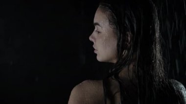 Çekici genç milenyum kızı duşun altında suyla tüm vücudunu ıslatıyor. Suyun, güzelliğin ve sağlık konseptinin altında duran damlaların altındaki ıslak genç kadın..