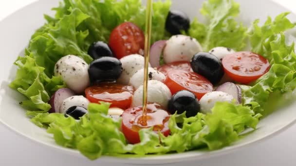 Se toarnă ulei de măsline peste salată vegetariană proaspătă de casă. Gătit salată de legume sănătoase cu brânză mozzarella și roșii cherry, prânz sănătos, alimentație ecologică curată, concept alimentar vegan dietă — Videoclip de stoc