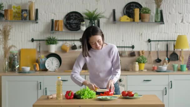 Gemengd race meisje snijden verse biologische komkommer voor groentesalade, glimlachen gelukkig aziatische vrouw bereiden gezonde veganistische maaltijd — Stockvideo