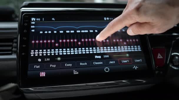 使用智能多媒体、现代触摸屏音频立体声系统、交通和车辆概念的人工手指更换汽车音频均衡器设置，以选择性焦点关闭 — 图库视频影像