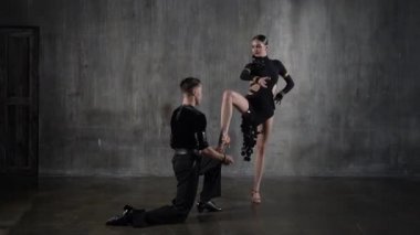 Milenyum dansları yapan, siyah elbiseli, homurdanarak dans eden genç ve zarif bir çift. Latin dansı yapan profesyonel dansçılar. Hobi dans konsepti. İnsani duygular, aşk ve tutku