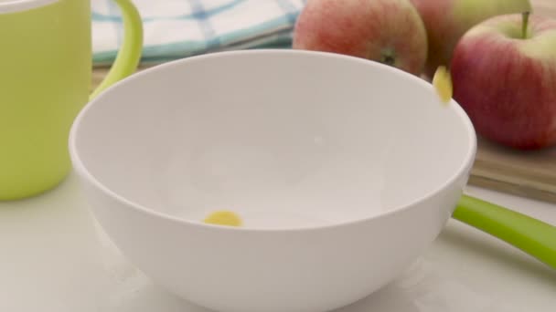 Corn flakes falling in white bowl — Stock Video