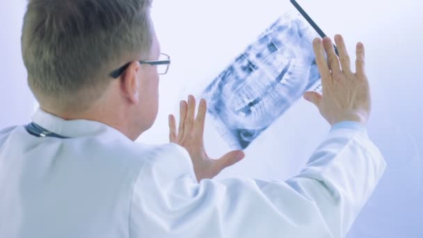 Mannelijke dokter kijkt naar röntgenfoto — Stockvideo