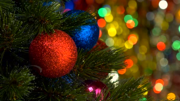 Κόκκινη Χριστουγεννιάτικη μπάλα και δέντρο πέρα από το υπόβαθρο που αναβοσβήνει — Αρχείο Βίντεο