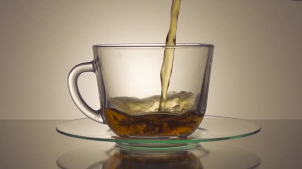 Té que se vierte en taza de té de vidrio — Vídeos de Stock