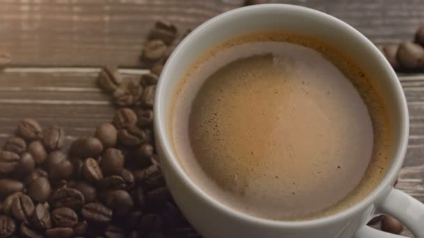 Xícara de café expresso fresco na mesa de madeira com feijão — Vídeo de Stock