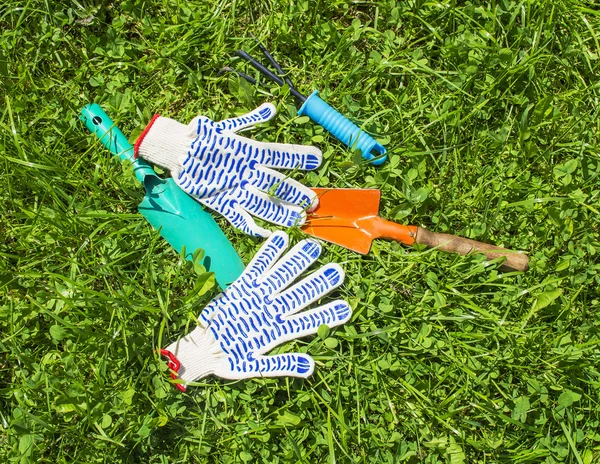 Herramientas y guantes de jardín sobre hierba —  Fotos de Stock