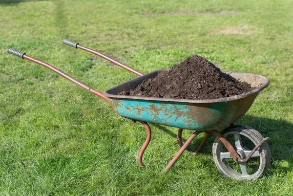 Carrinho de mão cheio de composto no gramado — Fotografia de Stock