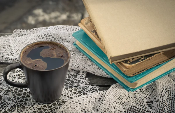 Чашка черного кофе и книги перед окном утром — стоковое фото