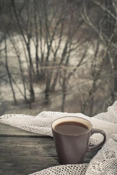 Чашка черного кофе перед окном и кружева на деревянном фоне . — стоковое фото