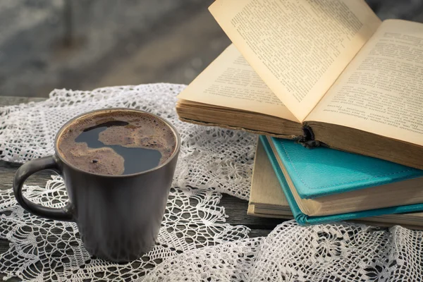 Чашка черного кофе и книги перед окном . — стоковое фото
