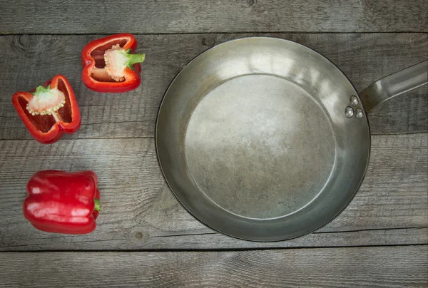 Red Paprika and pan on wooden board. Top view with copy space. — Stock Photo, Image