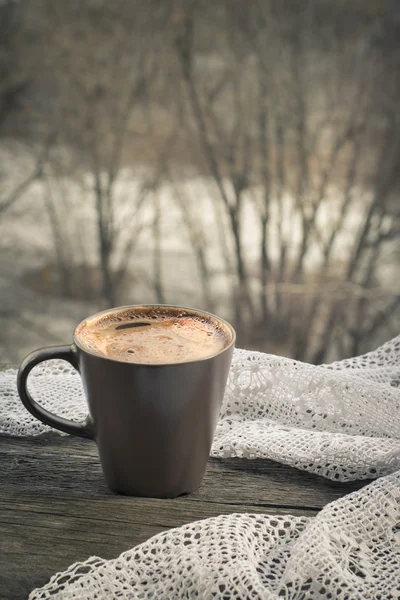 Чашка черного кофе перед окном и кружева на деревянном фоне . — стоковое фото