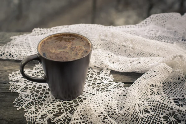 Xícara de café preto na frente da janela e renda em fundo de madeira . — Fotografia de Stock