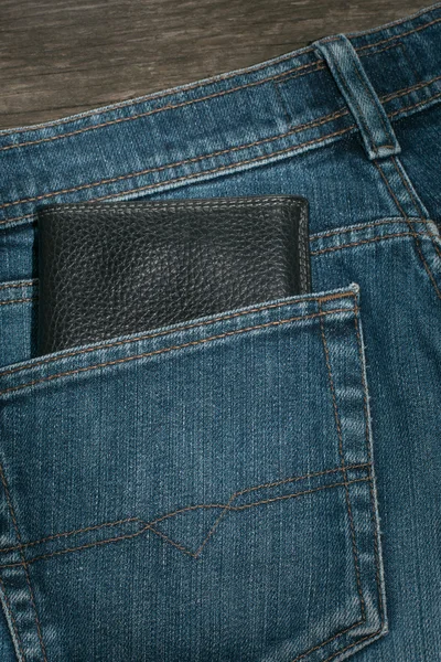 Zwarte portemonnee en blue jeans achterzak. — Stockfoto