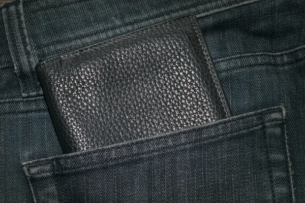 Zwarte portemonnee en blue jeans achterzak. — Stockfoto