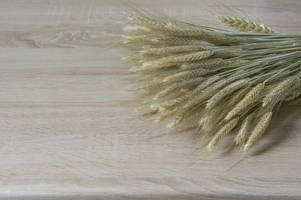 Wheat Ears on the Wooden Table. Sheaf of Wheat over Wood Background. Harvest concept
