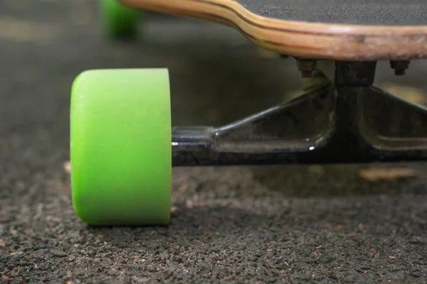 Staré použité skateboard izolovaných na zem. Starý styl longboard. Černá skateboard na prázdné asfaltové silnici. Malá hloubka ostrosti. — Stock fotografie