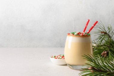 Beyaz üzerine renkli bayram yıldızları serpiştirilmiş Noel yumurtalı kokteyli. Kapatın. Uzayı kopyala Ulusal Eggnog Günü, 24 Aralık