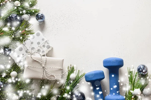 Mavi halterli Noel kompozisyonu, hediye, beyaz arka planda karlı köknar dalları. Kopya alanı olan Xmas fitness tebrik kartı.