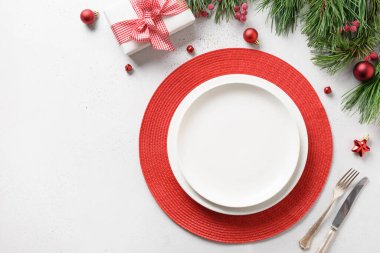 Beyaz masa üzerinde beyaz ve kırmızı bayram süslemeleri olan Noel kutlaması masası. Yukarıdan bak. Metin için boşluk.