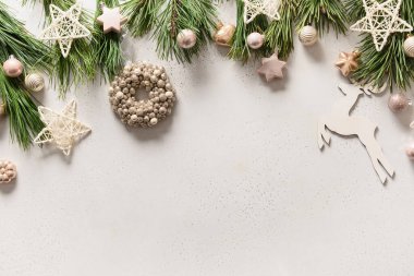 Beyaz çelenklerle, yıldızlarla, toplarla, kar taneleriyle, geyiklerle, her zaman yeşil dallarla dolu beyaz arka planda fotokopi aletiyle. Xmas tebrik kartı. Üst Manzara. Düzleştirme biçimi.