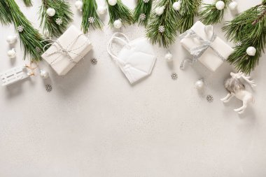 Tıbbi maskeli Noel beyazı süslemeler, beyaz arka planda yemyeşil dallar ve fotokopi alanı. Tıbbi Xmas tebrik kartı. Yukarıdan bak. Düzleştirme biçimi.