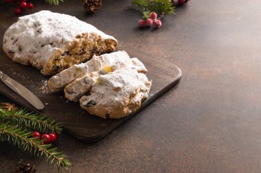 Christmas stollen - traditional German bread on brown background. Close up. clipart