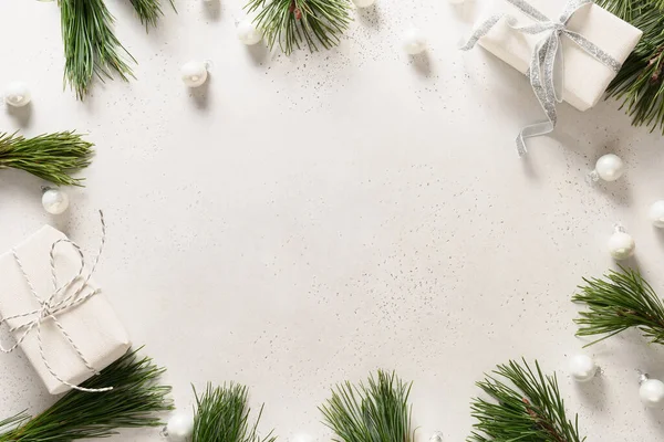 Noel beyaz çerçevesi hediyeler, toplar, her zaman yeşil dallar beyaz arka planda fotokopi alanı ile. Xmas tebrik kartı. Üst Manzara. Düzleştirme biçimi.