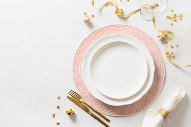 Beyaz üzerine pembe ve altın süslemeleri olan bir Noel sofrası. Yukarıdan bak. Metin için boşluk.