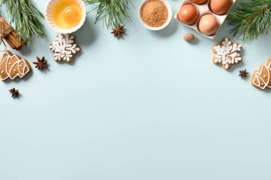 Mavi arka planda yemek pişirmek için malzemeli geleneksel Noel kurabiyeleri. Mesaj için yer var. Yukarıdan görüntüle.