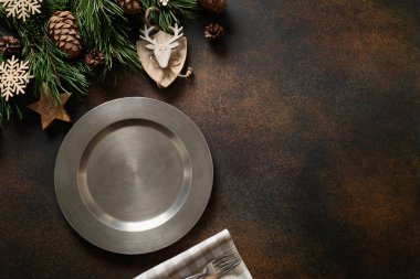 Noel masası seti, doğal dekorasyon ve kahverengi masada metalik plaka. Yukarıdan kopyalama alanı ile görüntüle.