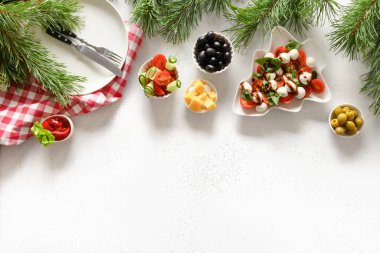 Caprese salatası ve çeşitli sebze tabakları ile Noel yemeği konsepti beyaz masada şenlikli Noel partisi için. Yukarıdan bak. Metin için boşluk.