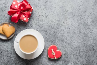 Bir fincan kahve, hediye ve kalp şeklinde kurabiyeler pembe arka planda aşk mektubu. Sevgililer günü kartı. Düz konum, üst görünüm, kopyalama alanı.