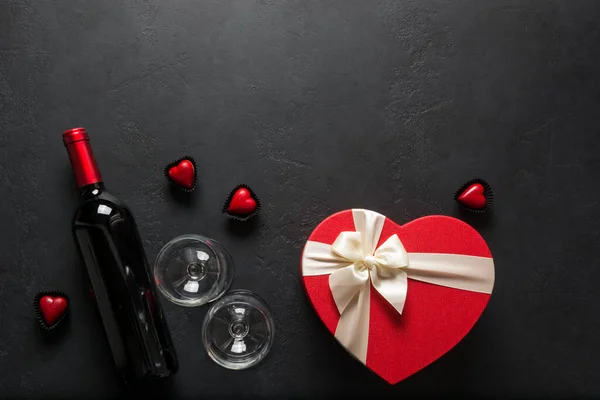 一壶红葡萄酒 酒杯和心脏礼物 背景是黑色的 情人节贺卡 情人节贺卡 从上面看案文的篇幅 — 图库照片