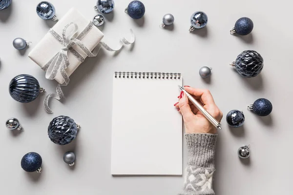 Navidad en blanco para la planificación de Año Nuevo en las manos de las mujeres con bolas azules. Vista desde arriba. —  Fotos de Stock