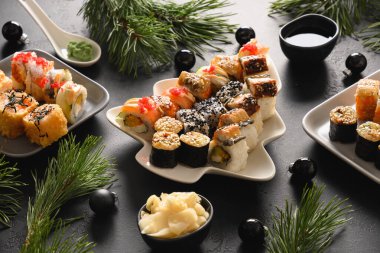 Noel yemeği, suşi seti ve siyah masa üzerine Xmas süslemesi. Kapatın. Yeni yıl partisi.