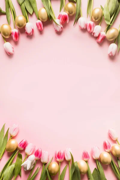 Tarjeta de felicitación de Pascua con tulipanes, huevos y conejito sobre fondo rosa con espacio para copiar. — Foto de Stock