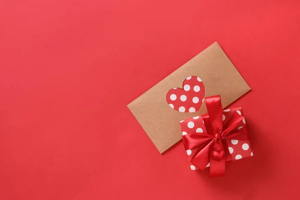 Dia dos Namorados cartão de saudação com presente e carta de amor no vermelho. Vista superior. — Fotografia de Stock