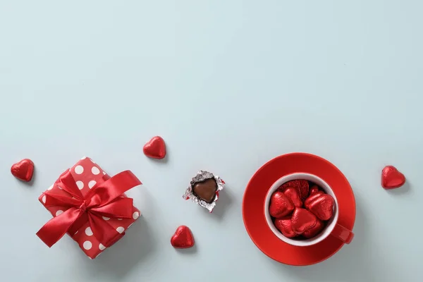 Red heart sweets, gift and cup on blue. Valentines day.