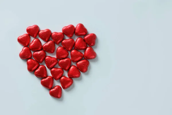 Rode chocolade hart van snoep op blauw. Valentijnsdag wenskaart. — Stockfoto